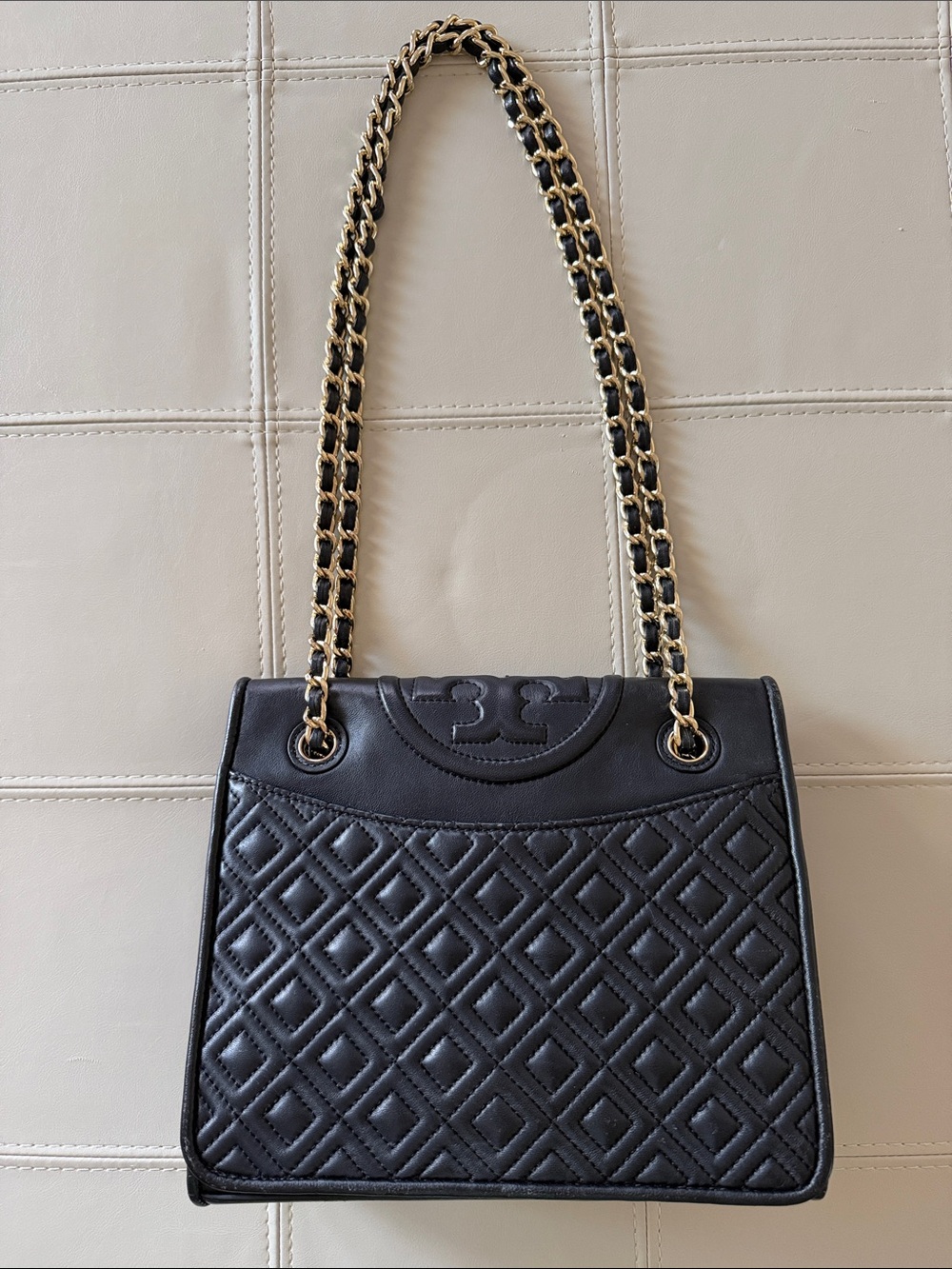 Tory Burch Fleming quilted shoulder bag in black leather with chain straps.